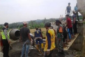 Babinsa Koramil Mandirancan saat membantu warga membangun bak penampungan air.